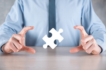 Businessman holds a piece of puzzle jigsaw in his hands.The concept of cooperation, teamwork, help...