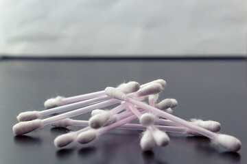 White cotton swabs on a dark background. Side view. The concept of using in cosmetic procedures,...