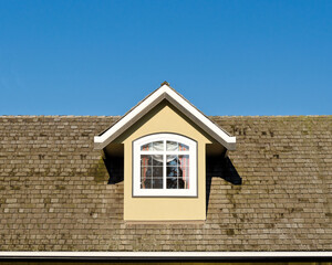 Window of a house roof with snow patches in shadows in Vancouver, Canada.