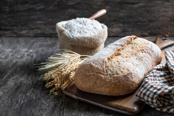 Fresh homemade bread and flour in small burlap bag