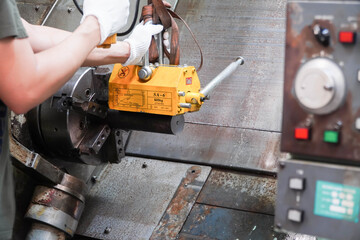 mechanic uses a magnet to lift the workpiece controlled by hand.