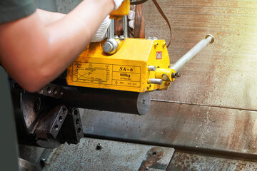 mechanic uses a magnet to lift the workpiece controlled by hand.