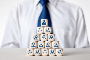 Tiered wooden cubes designed as organizational hierarchy with employee icons