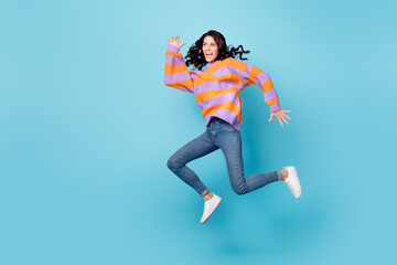Fototapeta na wymiar Full length body size view of pretty overjoyed cheerful wavy-haired girl jumping running having fun isolated over bright blue color background