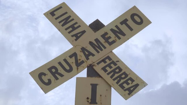 Rusty railway warning sign in Portuguese language
