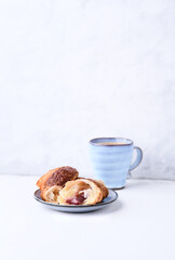 Croissant with coffee on bright wooden background. Copy space.