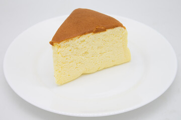 Fototapeta na wymiar Slice of Japanese Style Fluffy Cheesecake on a White Plate