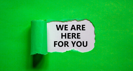 Support symbol. Words 'we are here for you' appearing behind torn green paper. Beautiful green background. Business and support concept. Copy space.