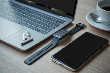 Close-up of Keyboard laptop computer, wireless earphones with smartwatch and smartphone empty...