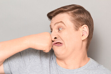 Obraz premium Portrait of funny crazy mature man punching himself in face