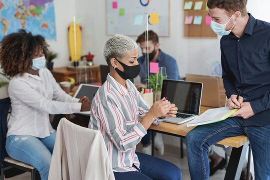 Multiracial people working inside coworking office with social distance and face masks