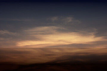 Horizontal landscape image blurred background. Mountain range in golden low light after sunset.