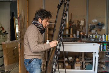 Man restoring a mirror - art, decoration and restoration concept