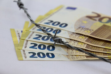 200 euro banknotes fanned with barbed wire and isolated on white