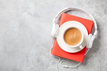 Headphones, book and cup of coffee on concrete surface - 426704697