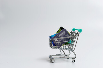 miniature shopping cart with credit cards isolated on light background