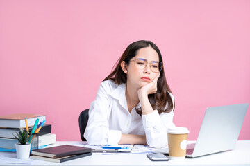 Young Asian women are tired from office work. Isolated Pastel Pink Background.