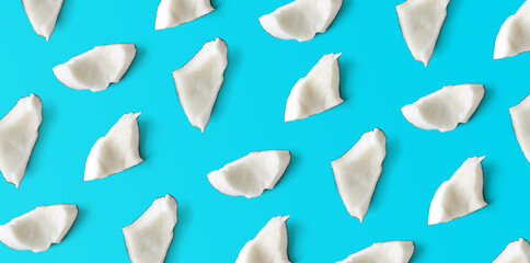 Coconut pieces pattern on blue background, from above