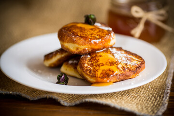 sweet fried cottage cheese pancakes with jam in a plate
