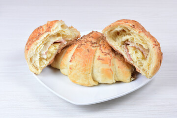 Cheese croissant, on white wooden background