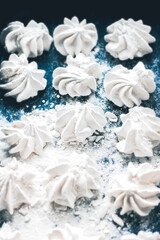 Meringue cookies on a blue background. Meringue background. Confectionery goodies