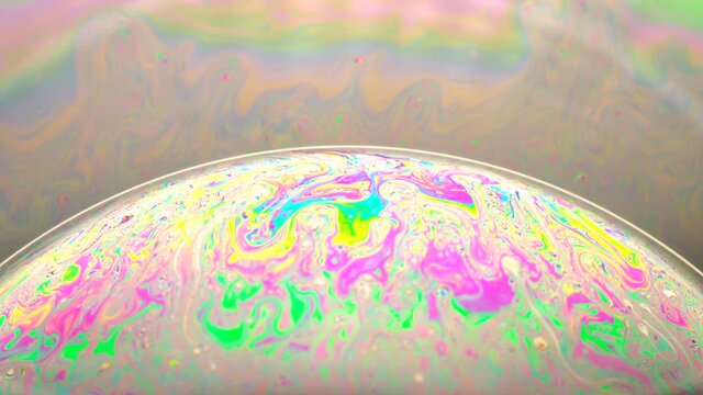 Fluid soap bubble looking like unknown planets. Psychedelic colorful abstract art with urreal patterns of color in motion.