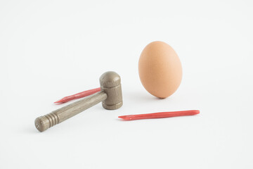 Creative composition with Easter egg, hammer and nail. Minimal holiday concept.