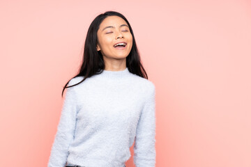 Fototapeta premium Teenager Chinese woman isolated on pink background laughing