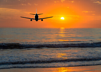 Sunset or sunrise (dawn, dusk ) flight of the airplane (jet) over beautiful sky and ocean.