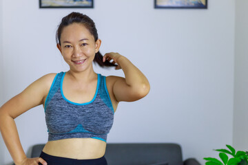 Fototapeta na wymiar Portrait photo of beautiful adult (40 years old) Asian woman in blue color Sports Clothing for doing Home Workout in the room white background.