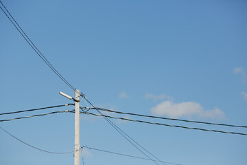 Lamp post and wires against the sky.