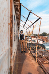 Steampunk. A hero on a river barge surrounded by steel mechanisms. A man with a weapon.