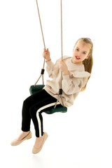 Beautiful teen school girl swinging on a swing. Concept summer vacation.