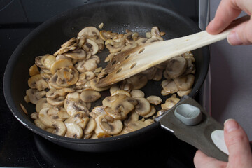 cocinando champiñones en una sarten