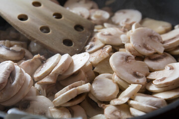 cocinando champiñones en una sarten