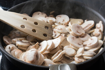 cocinando champiñones en una sarten