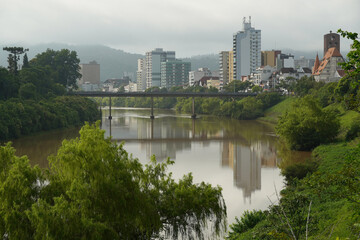Fototapeta na wymiar Stadtansicht von Blumenau, Santa Catarina mit Spiegelung im Wasser des Rio Itajai