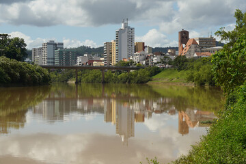 Fototapeta na wymiar Stadtansicht von Blumenau, Santa Catarina mit Spiegelung im Wasser des Rio Itajai