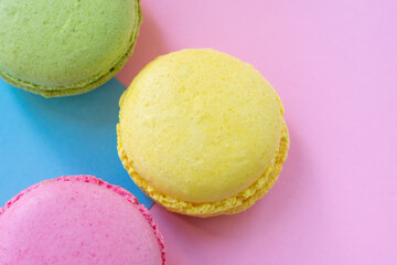 Three french traditional biscuits made of almond flour on two colored background blue and pink. Close up view