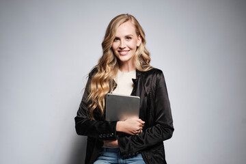 Portrait of an executive pretty blonde woman with her tablet while seated on a stool