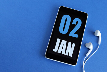 January 2. 2 st day of the month, calendar date. Smartphone and white headphones on a blue background. Place for your text. Winter month, day of the year concept.