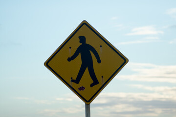 Pedestrian crossing sign with sky in the background