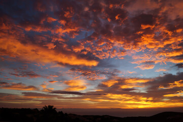 Fototapeta na wymiar warm orange golden cloudscape and beautiful sunrise over the sea