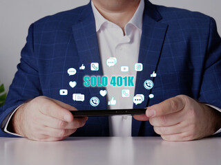  SOLO 401K inscription on the screen. Close up Merchant hands holding black smart phone.