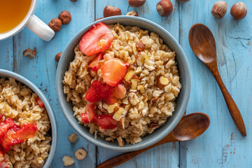 Oats porridge with hazelnuts and strawberry sorbet. Healthy breakfast ideas. Top view.