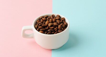 Coffee beans in white cup on a geometric two-tone pink and blue background