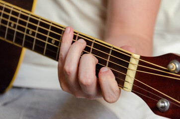Fototapeta na wymiar male fingers playing acoustics guitar strings
