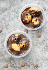 Profiteroles served in tubs with chocolate sauce