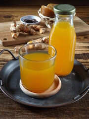 Jamu kunir asem or kunyit asam is Indonesian traditional herbal drink made from turmeric, tamarind, palm sugar. Served on tray with ingredients as background. Better served cold. Healthy refreshment.