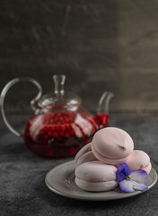 glass teapot with lingonberry drink on the table with fruit marshmallows
